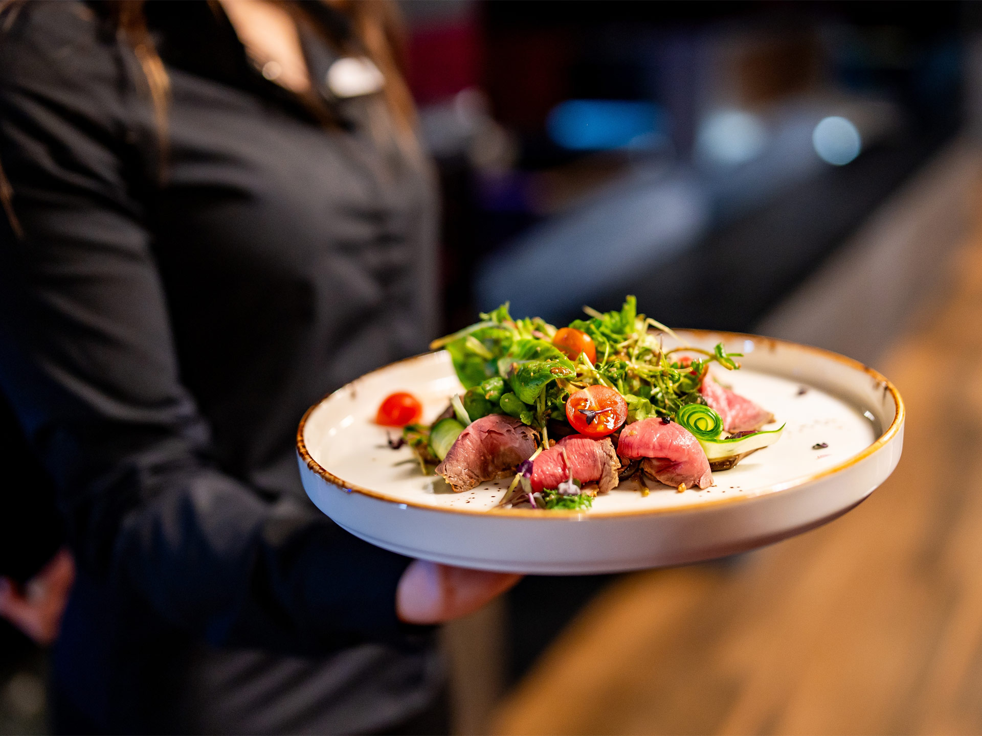 Waitstaff carrying plate of gourmet food Display Image